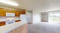 Located at 911 41st St NW in Rochester, Minnesota, this single-floor unit offers four bedrooms, two bathrooms, and a well-organized layout designed for comfortable everyday living. The open-concept kitchen and living room serve as the heart of the home, where warm oak cabinetry, a peninsula with a built-in sink and additional counter space, and white appliances — including a refrigerator, electric range, and microwave — create a practical and cohesive cooking area. Tile flooring anchors the kitchen, while plush carpet extends into the spacious living room, which features a sliding glass door that floods the space with natural light and opens to a view of lush green surroundings. The four bedrooms are carpeted and finished with neutral tones, offering a calm and restful atmosphere. The generously sized primary bedroom provides ample room for furnishings. The two bathrooms are finished with tile flooring, oak vanities with white countertops, and well-lit mirrors with strip lighting. A dedicated laundry room with a stacked washer and dryer unit and tile flooring adds everyday convenience. Textured ceilings and warm wood-toned trim are consistent throughout, giving the entire space a cohesive, understated character.