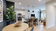 This thoughtfully designed 2-bedroom, 2-bathroom single-story residence offers an efficient and stylish open-concept layout. The combined kitchen, dining, and living area forms the heart of the home, anchored by a modern kitchen outfitted with white shaker cabinetry, subway tile backsplash, stainless steel appliances, and a dark-topped island with built-in sink and pendant lighting overhead — ideal for both cooking and casual dining. Light wood-look flooring flows throughout the main living areas, enhancing the bright, airy ambiance. The dining area features a bold dark accent wall, adding a striking contrast to the neutral tones of the rest of the space. The living room is comfortable and well-lit, benefiting from natural light through large windows dressed with rich navy drapes. The primary bedroom offers a carpeted retreat with elevated ceilings, generous natural light, and a spacious walk-in closet with wire shelving. A second bedroom provides equal comfort and flexibility. Both bathrooms are cleanly finished, with one featuring a full tub-shower combination with subway tile surround and matte black fixtures. With three closets and a dedicated hallway, storage and circulation are well-considered throughout this cohesive and modern residence.