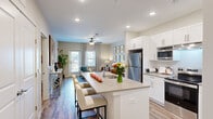 Located at 241 McArthur St in Lawrenceville, GA, this well-appointed one-bedroom, one-bathroom residence offers a thoughtfully designed single-floor layout. The open-concept kitchen is a standout feature, equipped with stainless steel appliances including a refrigerator, microwave, and range, complemented by crisp white cabinetry, light quartz countertops, and a central island with bar seating — ideal for both cooking and casual dining. Wood-style plank flooring flows throughout the main living areas, adding warmth and continuity to the space. The living room is bright and welcoming, benefiting from multiple windows that invite natural light and provide outdoor views, along with a ceiling fan for added comfort. A glass-panel door connects the living area to a private balcony. The bedroom is a calm retreat featuring plush carpet, dual windows with blinds and drapes, and a ceiling fan. It provides direct access to both a spacious walk-in closet with wire shelving and the full bathroom. The bathroom features wood-style flooring, a glass-enclosed shower, and a clean, neutral palette. Recessed lighting and ceiling fans throughout the home contribute to a modern, comfortable ambiance suited for everyday living.