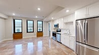 Located at 103 W College Ave in the heart of downtown Appleton, Wisconsin, this one-bedroom, one-bathroom unit offers a well-organized single-floor layout with a thoughtful mix of modern finishes and classic urban character. The combined kitchen and living area serves as the centerpiece of the unit, featuring a fully equipped kitchen with white shaker cabinetry, a subway tile backsplash, stainless steel appliances including a refrigerator, range, microwave, and dishwasher, and recessed lighting overhead. Polished large-format tile flooring runs throughout the main living spaces, reflecting natural light and lending an open, airy feel to the interior. Multiple tall windows invite generous amounts of natural light while framing views of the surrounding historic downtown buildings, adding a distinctive urban character to the space. The bedroom is a comfortable, well-proportioned room fitted with a ceiling fan, warm neutral walls, and access to a dedicated closet. The bathroom features a white vanity with a clean countertop, a large mirror, and matching tile flooring consistent with the rest of the unit. A dedicated closet provides additional storage. The overall ambiance is clean, modern, and bright, making this a well-appointed urban residence in a vibrant downtown location.