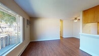This single-floor unit offers a practical and well-organized layout designed for comfortable everyday living. The main living area is finished with durable wood-style flooring and features a wall-mounted HVAC unit, a ceiling fan, and a large sliding window that fills the space with natural light and provides views of the surrounding neighborhood. A baseboard heating system runs along the perimeter, ensuring consistent warmth throughout.

The kitchen is configured in a galley style, with warm-toned wooden cabinetry lining both sides. It is equipped with a coil-burner electric range, a dishwasher, a refrigerator, and a double-basin stainless steel sink, offering a fully functional cooking space. A peninsula-style counter connects the kitchen to the living area, creating an open, connected feel.

Two bedrooms are finished with plush wall-to-wall carpeting and feature windows that bring in natural light, along with individual baseboard heating units. The neutral wall tones create a calm and versatile atmosphere in each room.

Two bathrooms serve the unit, both featuring tile-topped vanities with wood cabinetry, large mirrors, and wood-style flooring. One bathroom includes a glass-door shower enclosure, while the other offers a tiled shower-tub combination, providing flexible bathing options.