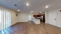 Located at 198 Littleton Road in Chelmsford, MA, this single-floor unit offers a clean, contemporary design with a thoughtfully open layout. The living area is generously proportioned, featuring warm hardwood-style flooring and recessed lighting throughout, creating a bright and welcoming atmosphere. Large sliding glass doors dressed with vertical blinds allow natural light to fill the space and provide a connection to the outdoors.

The kitchen is well-appointed and flows seamlessly into the living area. Rich dark-cherry cabinetry pairs with granite countertops and a peninsula that serves as both a prep surface and a casual dining space. A full suite of stainless steel appliances—including a refrigerator, electric range, microwave, and dishwasher—completes the kitchen.

The bathrooms are finished with the same hardwood-style flooring and dark-cherry vanity cabinetry. One bathroom features a walk-in shower with a clean white surround, while a second bathroom includes a soaking tub/shower combination with a window that brings in natural light.

Throughout the unit, neutral cream-toned walls, crisp white trim, and recessed lighting contribute to a modern, move-in-ready aesthetic that is both functional and visually cohesive.