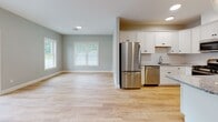 Located at 149 Main St in Upton, Massachusetts, this single-floor residence offers a well-designed layout that balances open living spaces with comfortable private rooms. The open-concept living and kitchen area is anchored by light hardwood flooring that extends throughout the main living spaces, creating a bright and cohesive aesthetic. Large sliding glass doors in the living area invite natural light and provide access to the outdoors, while additional windows frame views of the surrounding greenery.

The kitchen is thoughtfully appointed with white shaker-style cabinetry, granite countertops, a classic white subway tile backsplash, stainless steel appliances including a gas range, microwave, dishwasher, and refrigerator, and a pendant light fixture that adds a touch of warmth.

The bedrooms feature plush wall-to-wall carpeting and windows fitted with blinds that allow for natural light and privacy. The bathrooms are finished with granite-topped vanities, white cabinetry, tile flooring, and grab bars, reflecting a clean and accessible design. One bathroom includes built-in shelving for added storage convenience. Throughout the unit, soft neutral wall tones and clean white trim contribute to a fresh, move-in-ready atmosphere.