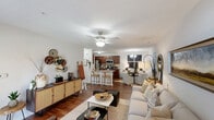 Located at 8037 Legends Dr in Southern Pines, NC, this single-floor, 2-bedroom, 2-bathroom home offers a thoughtfully designed open-concept layout that seamlessly connects the kitchen, dining, and living areas. The living room features rich hardwood floors, ceiling fan, and large windows that invite natural light, creating a bright and welcoming atmosphere. The kitchen is well-equipped with stainless steel appliances, warm cherry wood cabinetry, granite countertops, and a generous island with a double sink — ideal for both everyday cooking and entertaining. The primary bedroom is a comfortable retreat, complete with a ceiling fan and a closet, while the second bedroom offers plush carpeting and large windows with views of the surroundings. Both bathrooms are finished with granite-topped cherry wood vanities and tile flooring; the primary bath features a double-sink vanity and a shower-tub combination. A dedicated laundry room houses a full-sized washer and dryer. The overall ambiance throughout the home is clean and cohesive, with neutral tones, tasteful finishes, and a layout that balances functionality with comfort.