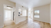 Located in San Antonio, TX, this one-bedroom, one-bathroom unit offers a practical and well-organized single-floor layout. The open living area features neutral-toned carpet, a ceiling fan, and a large window alongside a glass-panel door that leads out to a private balcony, filling the space with natural light and outdoor views. The kitchen is equipped with warm hardwood flooring, ample white cabinetry with wood trim, a double sink, dishwasher, and a white range — providing all the essentials for everyday cooking. The bedroom is a comfortable, carpeted retreat featuring two windows that invite natural light and greenery views, along with a ceiling fan for added comfort. The full bathroom includes a wide vanity with wood-accented cabinetry, a large mirror, tiled shower/tub combo, and direct access to a walk-in closet with built-in shelving. A second closet provides additional storage. An in-unit laundry area adds convenience to daily routines. Throughout the unit, a consistent neutral color palette, clean white trim, and a mix of hardwood and carpet flooring create a cohesive and functional living environment.