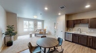 Located on 25th St S in Fargo, North Dakota, this single-floor residence offers a thoughtfully designed layout that balances open communal spaces with private retreats. The open-concept living and dining area serves as the heart of the home, where light-toned walls, recessed lighting, and large windows allow natural light to fill the space. Durable light wood-look flooring flows through the main areas, while plush carpet adds warmth to the living room and bedrooms.

The kitchen is well-equipped with rich dark cabinetry, stainless steel appliances including a refrigerator, range, microwave, and dishwasher, and clean white countertops. A round dining table sits adjacent to the kitchen, creating a seamless transition between cooking and dining.

The living room offers a relaxed atmosphere with ample natural light streaming through multiple windows and access to an exterior door, bringing in views of the surrounding neighborhood. Each bedroom is a calm, neutral retreat featuring carpeted floors and generously sized windows.

The primary bathroom includes a double-sink vanity with dark cabinetry and a stand-alone shower, while the secondary bathroom features a combined tub and shower with matching dark wood cabinetry. Both bathrooms are finished with light wood-look flooring, creating a cohesive aesthetic throughout the entire residence.