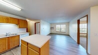Located at 680 12th St SW in Forest Lake, Minnesota, this 2-bedroom, 2-bathroom unit offers a well-organized, single-floor layout designed for comfortable everyday living. The kitchen is a standout feature, equipped with warm oak cabinetry, white appliances including a refrigerator, electric range, and dishwasher, ample counter space, and a center island that provides additional workspace and casual dining potential. Light wood-style flooring runs through the kitchen and living areas, creating a cohesive and easy-to-maintain surface throughout the main spaces. The combined kitchen and living room area provides an open, functional flow ideal for both relaxing and entertaining. Both bedrooms are carpeted and receive natural light through windows with views of surrounding greenery, with baseboard heating ensuring year-round comfort. The primary bedroom is a well-proportioned retreat. The two bathrooms feature wood-toned vanity cabinetry, light flooring, and clean, neutral finishes. Additional storage is provided by a dedicated closet. A wall-mounted air conditioning unit is present in the living area. The unit's warm neutral color palette, oak wood trim, and textured ceilings contribute to a cozy, understated ambiance throughout.