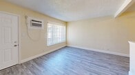 Located at 2509 Edison Ave in Sacramento, CA, this efficient one-bedroom, one-bathroom unit offers a well-organized single-floor layout comprising a living room, bedroom, bathroom, and hallway. Throughout the unit, contemporary gray luxury vinyl plank flooring adds a clean, modern aesthetic that ties each room together seamlessly.

The living room is a bright, open space featuring warm beige walls, a textured ceiling, and a wall-mounted air conditioning unit. A peninsula-style counter separates the kitchen area, providing a functional pass-through that enhances the open feel of the main living space. A ceiling fan is also present, contributing to comfortable airflow.

The bedroom is a well-proportioned retreat featuring a ceiling fan with light fixture, a window with vertical blinds that welcomes natural light and outdoor views, and a sliding-door closet offering practical storage. The hallway connects the rooms efficiently, also providing additional closet access.

The bathroom is neatly appointed with a clean white vanity and sink, and a tub/shower combination finished with large-format marble-look porcelain tile in a striking white and grey veining pattern, accented with gold grout — a refined detail that elevates the overall finish of the space. The consistent flooring throughout ties the entire unit together with a cohesive, updated look.