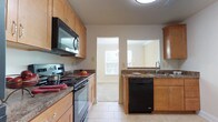 This two-floor home offers a practical and comfortable layout with consistent finishes throughout. The kitchen is well-appointed with light maple cabinetry, dark granite-style countertops, and a full suite of black appliances including a refrigerator, electric range, over-the-range microwave, and dishwasher. Light tile flooring runs throughout the kitchen, which also features a pass-through window connecting to an adjacent area, enhancing the open feel of the space.

The main living area on the first floor is carpeted and brightened by natural light through multiple windows with blinds. A staircase leads to the upper level, where additional carpeted bedrooms are found. One upper bedroom features vaulted ceilings and a large window with outdoor views, lending a bright and airy character to the space. Other bedrooms on this level are well-sized with generous windows that bring in ample natural light and views of surrounding greenery.

The home includes two full bathrooms, each featuring a soaking tub and shower combination with beige tile surrounds and chrome fixtures, providing a clean and neutral aesthetic. Neutral wall tones, wall-to-wall carpeting in the living and bedroom areas, and consistent trim work throughout create a cohesive and move-in ready environment across both floors.