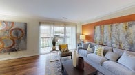 Located at 2211 Valleywood Dr SE in Grand Rapids, Michigan, this single-floor residence offers a thoughtfully designed layout with comfortable living spaces throughout. The living room serves as the heart of the home, featuring rich hardwood flooring, crown molding, and a bold warm-toned accent wall that anchors the space. Large sliding glass doors flood the room with natural light and open to a private balcony with outdoor views. The kitchen is outfitted with dark cabinetry, granite countertops, a double-basin sink, and black appliances, creating a sleek, modern aesthetic complemented by hardwood floors. Two bathrooms feature granite vanity countertops and white cabinetry; one includes a full tub-shower combination with tile surround. The bedrooms are carpeted and well-sized, with large windows allowing ample natural light. The primary bedroom includes a spacious louvered double-door closet with direct access to an ensuite bathroom. An additional flexible room with carpet and windows provides space suitable for a home office or secondary lounge. Throughout the residence, neutral wall tones provide a clean, versatile backdrop that ties each room together cohesively.