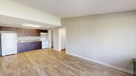 Located in Miami, FL, this one-bedroom, one-bathroom residence offers a practical and well-organized single-floor layout. Wood-look flooring runs throughout, lending a warm, cohesive feel to every room. The open-plan kitchen and living area forms the heart of the home, where dark-stained wood cabinetry with granite-style countertops pairs with white appliances — including a refrigerator and electric range — beneath a skylight-style ceiling fixture that brightens the space. A textured ceiling adds subtle character throughout. The living area is open and airy, with a large sliding window framing views of mature palm trees and lush greenery outside, bringing a touch of Miami's tropical landscape indoors. A front entry door with an adjacent window further enhances natural light. The bedroom is a comfortable retreat, equipped with a ceiling fan, a window overlooking green foliage, and convenient closet access. The bathroom features a full tub-shower combo with clean white tile surround. Two closets and a dedicated utility room provide practical storage and functionality. The hallway connects all areas efficiently, completing this tidy, move-in-ready residence.