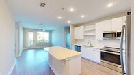 Located at 741 Clay St in Winter Park, FL, this thoughtfully designed 2-bedroom, 2-bathroom residence offers a clean, modern aesthetic across a single floor. The open-concept living area seamlessly connects the kitchen, dining, and living spaces, all finished with light wood-tone flooring and neutral tones that create a bright, airy atmosphere. Ceiling fans are featured throughout, enhancing comfort in each room.

The contemporary kitchen is a standout, boasting sleek flat-front white cabinetry, open shelving, a central island with light quartz countertops, and a full suite of stainless steel appliances. Recessed lighting illuminates the space efficiently.

Both bedrooms are well-sized and filled with natural light from large windows with outdoor views. The primary bedroom features a ceiling fan and direct access to a spacious, custom-organized walk-in closet with built-in shelving and drawers. The second bedroom also enjoys outdoor views and a ceiling fan.

The two bathrooms offer clean, modern finishes — one includes a tiled soaking tub and shower combo, while the other features a sleek glass-enclosed walk-in shower with white tile surround. In-unit laundry adds further convenience to this well-appointed home.