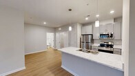 Located in Anderson, SC, this thoughtfully designed one-bedroom, one-bathroom residence offers a modern aesthetic combined with functional living. The open-concept kitchen and living area serves as the heart of the home, anchored by a central island with a sleek marble-look countertop, undermount sink, and pendant lighting above. The kitchen is fully equipped with stainless steel appliances—including a refrigerator, electric range, microwave, and dishwasher—complemented by gray shaker-style cabinetry and ample counter space. Warm-toned luxury vinyl plank flooring flows seamlessly throughout the entire unit, creating a cohesive and easy-to-maintain surface underfoot. The living area is bright and open, with natural light filtering in and a ceiling fan overhead. The spacious primary bedroom offers a comfortable retreat with a ceiling fan, a large window with outdoor views, and direct access to a dedicated walk-in closet equipped with wire shelving. The walk-in closet also conveniently houses the laundry connections. The bathroom features coordinating gray cabinetry and clean, contemporary finishes. Neutral wall tones throughout the home provide a versatile backdrop, completing this modern and move-in-ready residence.