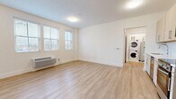 Located at 11 1st Ave in Bay Shore, NY, this thoughtfully designed two-bedroom, two-bathroom residence offers a clean, modern aesthetic across a single floor. Light wood-style flooring flows seamlessly throughout the space, complementing the crisp white walls and bright, airy atmosphere found in every room.

The living room is a welcoming, open area bathed in natural light from multiple windows fitted with blinds. A wall-mounted HVAC unit provides efficient climate control, and the neutral palette creates a versatile backdrop for any furnishing style.

Both bedrooms continue the same light, contemporary feel, with large windows that invite abundant daylight. The primary bedroom offers a comfortable footprint well-suited for a full furniture arrangement.

The two bathrooms are finished to a high standard. One features a soaking tub with a full tiled surround and a chrome multi-function shower system, paired with a floating wood-toned vanity, a mirrored medicine cabinet, and light tile flooring. The second bathroom includes a glass-enclosed walk-in shower with white tile, adding a sleek, spa-like touch.

A dedicated utility room houses a stacked washer and dryer, providing the convenience of in-unit laundry. Clean lines, consistent finishes, and practical amenities make this residence a polished and functional home in the heart of Bay Shore.