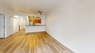 Located at 2615 1st Ave in Seattle's Belltown neighborhood, this two-bedroom, one-bathroom residence offers a well-organized single-floor layout designed for comfortable urban living. Light hardwood flooring flows consistently throughout, lending a clean, cohesive aesthetic to the entire space.

The living room is generously proportioned, bathed in natural light from a large bank of floor-to-ceiling windows, and features crown molding and a ceiling fan. It connects openly to the kitchen via a half-wall pass-through, creating an airy, social atmosphere. The kitchen is well-appointed with warm wood cabinetry, dark granite countertops, a tile backsplash, and a full suite of stainless steel appliances including a gas range, microwave, refrigerator, and dishwasher.

The primary bedroom is a comfortable, light-filled room featuring a window with outdoor views, while the second bedroom is equally bright with its own window. A dedicated closet provides organized storage with built-in hanging rods. The bathroom includes a granite-topped vanity with warm wood cabinetry, a tub-shower combination with decorative tile accenting, and light flooring that ties the space together. An in-unit laundry area adds everyday convenience to this well-appointed Seattle residence.