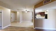 This single-floor residence offers a thoughtfully designed layout that balances comfort and functionality. The open-concept living and dining area is finished with light ceramic tile flooring and features a ceiling fan with light fixture, creating a bright and airy atmosphere. Warm beige walls carry throughout the space, lending a cohesive and welcoming feel.

The kitchen is efficiently designed in a galley style, featuring rich dark wood cabinetry, black appliances including a range, over-the-range microwave, and refrigerator, along with a double-basin sink and light tile flooring. A pass-through opening connects the kitchen to the living area, enhancing the open flow of the space.

The bedrooms are generously sized, each featuring durable wood-look flooring and neutral walls. Both rooms are filled with natural light courtesy of large windows fitted with blinds, and one bedroom offers sliding glass doors leading to additional space. The primary bedroom connects to an en-suite bathroom complete with a long vanity, dark wood cabinetry, a wide mirror, mirrored closet doors, and a separate water closet. A second bathroom provides a tiled tub-shower combination, toilet, and vanity, maintaining the same warm, neutral palette found throughout the home.