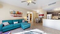 Located at 9971 E Speedway Blvd in Tucson, Arizona, this single-story residence offers a well-designed, open-concept layout with wood-look flooring flowing throughout the main living areas. The living room is bright and inviting, featuring a ceiling fan, vaulted ceilings, and generous natural light, creating a comfortable and airy atmosphere. A dedicated entertainment area with additional storage is positioned near the front entry.

The kitchen is equipped with stainless steel appliances — including a full-size refrigerator, electric range, and microwave — complemented by dark cabinetry and a peninsula with a sink that seamlessly connects to the dining area. The adjacent dining space accommodates a full table and chairs, anchored by bold wall art that adds character to the room.

The primary bedroom is spacious and includes a ceiling fan, direct access to a private patio through sliding glass doors, and ample room for large furnishings. A full bathroom features a tub/shower combination and vanity with a light countertop. A secondary bedroom provides flexible sleeping arrangements with room for multiple occupants and benefits from natural light via a window. A dedicated laundry closet houses a full-size side-by-side washer and dryer for added convenience. This residence delivers functional, comfortable living in an efficiently organized single-floor plan.