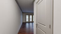 Located at 1023 Everett Ave in Louisville, KY, this two-bedroom, one-bathroom unit offers a well-organized single-floor layout designed for comfortable everyday living. A welcoming hallway with rich, dark hardwood-style flooring leads into an open living and dining area filled with natural light from a set of elegant French doors that open to an outdoor balcony view. Crown molding adds a refined touch to the living spaces, while a wall-mounted mini-split unit provides efficient climate control.

The kitchen features dark cabinetry, granite countertops, a subway tile backsplash, stainless steel appliances including a full-size refrigerator and dishwasher, and a pass-through window connecting to the dining area. Track lighting illuminates the space effectively.

Both bedrooms are carpeted for warmth and comfort, each equipped with a ceiling fan and closet storage. The primary bedroom includes a built-in closet with bifold doors, while a secondary bedroom offers a bright window with outdoor views. Three closets throughout the unit provide ample storage.

The bathroom is finished with white subway tile surrounding a full soaking tub and shower, complemented by mosaic accent tile and light stone-look flooring. A dedicated laundry area rounds out this efficiently designed home.