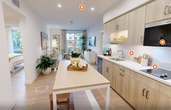 This contemporary 780 square foot apartment offers a thoughtfully designed living space with two bedrooms and two bathrooms. The heart of the home is an open-concept kitchen and living area, promoting a seamless flow for daily life and entertaining. The kitchen boasts light wood cabinetry, stainless steel appliances, and a practical island, perfect for meal preparation or casual dining.

The living room is bathed in natural light from large windows, which also provide views of the surrounding area. A cohesive color scheme of neutrals accented with pops of yellow creates a cheerful and inviting atmosphere throughout. The primary bedroom, measuring 140 square feet, offers ample space and includes built-in storage solutions.

Both bathrooms feature modern fixtures, glass shower enclosures, and wood-look flooring that extends throughout the apartment. The overall design emphasizes functionality without sacrificing style, incorporating elements like strategically placed artwork, indoor plants, and a mix of textures to add visual interest.

The apartment's layout maximizes the use of space, with a hallway providing easy access to all rooms. Despite its compact size, the home feels spacious and airy, thanks to its thoughtful design and abundant natural light.