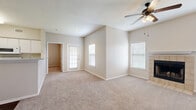 Located at 500 W Cartwright Rd in Balch Springs, TX, this single-story, 2-bedroom, 2-bathroom home offers a practical and comfortable layout throughout. The open living room is a welcoming centerpiece, featuring plush carpeting, a ceiling fan with light fixture, multiple windows with blinds that invite ample natural light, and a tiled fireplace that adds warmth and character to the space. The kitchen is well-appointed with white cabinetry, a full suite of white appliances including a refrigerator, electric range, and microwave, as well as a sink and durable wood-look flooring that extends into the bathrooms. Both bedrooms are carpeted and include ceiling fans. The spacious primary bedroom offers direct access to a private en-suite bathroom and a walk-in closet outfitted with wire shelving for organized storage. The second bedroom is similarly bright with a window and ceiling fan. Both bathrooms feature white vanities, mirrors, and wood-look flooring; the second bathroom includes a tub-shower combination with white tile surround. Two dedicated closets throughout the home provide generous storage. The neutral color palette and clean finishes create a cohesive, move-in-ready atmosphere throughout the entire home.