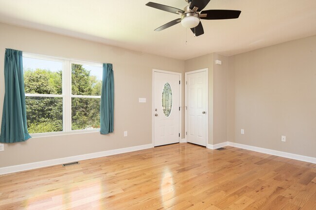 Sala de estar frontal con pisos de madera noble y grandes ventanales para dejar entrar la luz. - 2208 Southside Rd