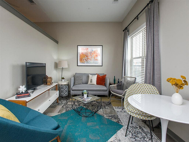 Experience the allure of this chic city living room, perfect for both relaxation and entertainment. - Eastside Heights