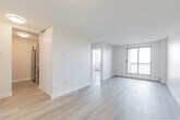 Located at 44 Glen Rd in Hamilton's desirable west end, this two-bedroom, one-bathroom unit offers a well-organized single-floor layout designed to maximize every square foot. Light wood laminate flooring flows consistently throughout, lending a clean, contemporary feel to the space.

The compact kitchen is thoughtfully outfitted with modern light wood cabinetry extending to the ceiling for ample storage, stainless steel appliances including a refrigerator and built-in microwave, a smooth-top range, and a white countertop work surface — all beneath a textured ceiling with flush-mount lighting.

The spacious primary bedroom is a standout feature, offering generous room with a large sliding glass door that opens directly to a private balcony, providing elevated views of the surrounding treetops and landscape. A second bedroom features a bright window framing similar scenic views, along with a built-in closet and baseboard heating.

The bathroom is finished with floor-to-ceiling cream subway tile surrounding a full soaker tub and shower combination, complemented by a wall-mounted mirror and classic white fixtures.

Neutral wall tones, baseboard heating throughout, and access to outdoor space make this a bright, functional unit well-suited for comfortable everyday living in Hamilton.