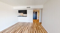 Located at 1515 W Missouri Ave in Phoenix, AZ, this single-floor residence offers a clean, modern aesthetic throughout. Fresh light wood-tone flooring runs continuously across the living spaces, providing a warm and cohesive look. The open living area is anchored by a kitchen pass-through counter with dark cabinetry above, creating a natural visual divide while maintaining an open feel. A textured ceiling adds a classic residential touch throughout the unit.

The galley-style kitchen is efficiently designed, featuring dark lower and upper cabinetry, light countertops, a stainless steel sink with a contemporary faucet, and full appliances including a refrigerator and range. Recessed lighting illuminates the kitchen corridor.

The sleeping areas are bright and airy, with large windows and sliding glass doors that invite natural light and offer views of the outdoor surroundings. Vertical blinds provide privacy and light control. One room includes direct access to a dedicated closet space with built-in shelving, offering practical storage solutions.

The unit also features a walk-through hallway with additional built-in shelving, a bold navy entry door, and well-maintained white walls throughout, giving the space a fresh, move-in-ready appearance. Overall, the unit presents a functional and updated living environment in central Phoenix.