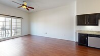 Located at 1520 16th St in Sacramento, CA, this well-appointed one-bedroom, one-bathroom unit offers a thoughtfully designed single-floor layout. The open-concept kitchen and living area serves as the heart of the home, featuring rich hardwood-style flooring throughout. The kitchen is equipped with stainless steel appliances — including a refrigerator, range, microwave, and dishwasher — complemented by granite countertops and dark espresso cabinetry that provide both style and ample storage. The living area is bright and airy, highlighted by a ceiling fan and a sliding glass door that opens to a private balcony, allowing natural light to fill the space and offering pleasant outdoor views. The bedroom is a comfortable retreat finished with plush carpeting, a large window that invites natural light, and access to a dedicated closet. An arched architectural detail connects the bedroom corridor, adding a subtle design flourish. The bathroom features hardwood-style flooring, a granite-topped vanity with dark cabinetry, a large mirror with elegant vanity lighting, and a shower-tub combination. A hallway connects the rooms efficiently, rounding out this clean, functional, and inviting home.