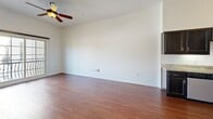 Located at 1520 16th St in Sacramento, CA, this well-appointed one-bedroom, one-bathroom unit offers a thoughtfully designed single-floor layout. The open-concept kitchen and living area serves as the heart of the home, featuring rich hardwood-style flooring throughout. The kitchen is equipped with stainless steel appliances — including a refrigerator, range, microwave, and dishwasher — complemented by granite countertops and dark espresso cabinetry that provide both style and ample storage. The living area is bright and airy, highlighted by a ceiling fan and a sliding glass door that opens to a private balcony, allowing natural light to fill the space and offering pleasant outdoor views. The bedroom is a comfortable retreat finished with plush carpeting, a large window that invites natural light, and access to a dedicated closet. An arched architectural detail connects the bedroom corridor, adding a subtle design flourish. The bathroom features hardwood-style flooring, a granite-topped vanity with dark cabinetry, a large mirror with elegant vanity lighting, and a shower-tub combination. A hallway connects the rooms efficiently, rounding out this clean, functional, and inviting home.