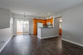 Located at 8250 Vineyard Ave in Rancho Cucamonga, CA, this two-story home offers a well-organized layout designed for comfortable everyday living. The entry level welcomes you through a front door that opens to a foyer with direct views of the neighborhood and mountain backdrop, with a staircase leading to the upper floor. The garage level features a spacious attached garage with a concrete floor and automatic opener, providing ample room for vehicles and storage.

The kitchen is outfitted with warm honey-toned wood cabinetry, granite-style countertops, and white appliances including a range, built-in microwave, dishwasher, and refrigerator. Wood-look flooring flows throughout the main living areas, lending a cohesive and easy-to-maintain aesthetic. The bathroom is clean and functional, featuring a tub-shower combination with white tile surround, wood-look flooring, and a vanity with granite-style countertops.

Upstairs, the bedrooms are carpeted and bright, each featuring mirrored sliding closet doors with built-in shelving. The primary bedroom includes a ceiling fan, a sliding glass door opening to a private balcony, and an en-suite access point. Additional bedrooms are well-lit by natural light through window blinds. The home's neutral palette and practical finishes make it a versatile and move-in-ready residence.