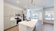 Located at 1735 N Greenville Ave in Richardson, TX, this well-appointed one-bedroom, one-bathroom unit offers a thoughtfully designed single-floor layout with modern finishes throughout. The open-concept living area seamlessly connects the kitchen, dining, and living spaces, creating an airy and functional hub for everyday living. The kitchen is a standout feature, boasting a large center island with a white quartz countertop and an undermount sink, complemented by sage-toned cabinetry, a white subway tile backsplash, and a full suite of stainless steel appliances. Pendant lighting above the island adds a contemporary touch, while wood-look flooring flows throughout the space. Adjacent to the kitchen is a built-in bar or serving area with matching cabinetry and a wine rack, ideal for entertaining. The living area benefits from natural light streaming through a large window. The bedroom is a comfortable retreat with its own window view and direct access to the full bathroom, which features a tiled soaking tub and shower combo, wood-look flooring, and sage cabinetry vanity. A dedicated office provides flexible workspace, and multiple closets offer generous storage. Double panel doors add an elegant architectural detail to the entry.