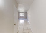 Located at 7325 SW 82 St in Miami, FL, this single-story home offers a clean, functional layout finished consistently with gleaming large-format white tile flooring throughout. A central hallway connects the living areas to the private quarters, allowing for an intuitive flow between spaces.

The open living and dining areas are bright and airy, with a classic chandelier anchoring the dining space and natural light streaming in through gridded windows. The expansive, neutral-toned walls provide a versatile backdrop for any décor style.

The kitchen features dark espresso cabinetry with modern hardware, granite countertops, a stainless steel sink, and a dishwasher — offering both style and practicality in a compact footprint.

The bedrooms are well-proportioned, each equipped with ceiling fans with light fixtures for year-round comfort. At least one bedroom includes a sliding-door closet and a window with vertical blinds, allowing for ample natural light and storage.

The bathroom is outfitted with warm beige wall tile surrounding a full tub and shower combination, complemented by a vanity with granite countertops, a dark wood cabinet base, and a well-lit mirror — creating a cohesive and updated aesthetic throughout this Miami home.
