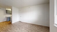 Located at 1610 E McKinney St in Denton, TX, this single-floor, 2-bedroom, 1-bathroom unit offers a practical and well-organized layout. Wood-look flooring runs throughout the entire space, providing a consistent and easy-to-maintain surface across every room. The living room greets you at the entrance with a window that allows natural light in and offers a view of the surrounding neighborhood. The kitchen is equipped with gray cabinetry, light countertops, a tile backsplash, a stainless steel sink, and a black gas range, offering a functional cooking space with a clean, updated aesthetic. Both bedrooms feature ceiling fans with light fixtures and are finished with the same wood-look flooring. The primary bedroom is a comfortable size and includes access to a dedicated closet. The second bedroom also benefits from a ceiling fan and a window that brings in natural light. The bathroom includes a full tub-shower combo with white tile surround, brushed nickel fixtures, and a gray wall-mounted storage cabinet for additional organization. Textured ceilings are present throughout the unit, adding a classic residential character to the overall interior.