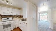Located at 8507 Magnolia Ave in Riverside, California, this one-bedroom, two-bathroom unit offers a well-organized single-floor layout designed for comfortable everyday living. The kitchen is a functional highlight, featuring white cabinetry, a mosaic tile backsplash, white appliances including a refrigerator, electric range, microwave, and dishwasher, warm wood-style flooring, and track lighting overhead — making it both practical and visually clean. The bedroom is a comfortably sized retreat with soft carpeting, neutral walls, and a window that invites natural light and views of the surrounding greenery. The living area continues the carpeted flooring and open, airy feel with neutral tones throughout. The two bathrooms offer contrasting but complementary designs: one features wood-style flooring, a wall-mounted sink, vanity mirror with overhead lighting, and a built-in cabinet; the other includes a sliding-door shower enclosure with frosted glass panels and a grab bar, adding a practical touch. Throughout the unit, the clean white walls and light-filled spaces create a bright, straightforward ambiance. The efficient layout makes excellent use of every square foot, offering a cohesive and move-in-ready living environment in a convenient Riverside location.
