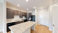 Located at 5375 Allatoona Gateway in Acworth, Georgia, this 1-bedroom, 1-bathroom residence offers a thoughtfully designed single-level layout that maximizes every square foot. Light-toned hardwood-style flooring runs consistently throughout, lending warmth and visual continuity to the entire space.

The kitchen serves as the focal point of the open-concept living area and is outfitted with rich, dark espresso cabinetry, light granite countertops, a tile backsplash, and black appliances including a range, dishwasher, and refrigerator. A peninsula island with a matching granite surface provides additional prep space and casual seating, while recessed lighting illuminates the area efficiently.

The living area flows naturally from the kitchen, benefiting from a window that allows natural light to fill the space. The bedroom is a comfortable, well-proportioned room featuring a ceiling fan with light fixture, a large window with blinds that invite natural light, and light neutral walls that create a calm atmosphere.

The bathroom is clean and functional, featuring a walk-in shower with accessibility grab bars, a dark vanity cabinet topped with a granite countertop, and a well-lit mirror above the sink. A hallway connects the rooms and includes additional storage access. The overall ambiance is modern, clean, and move-in ready.