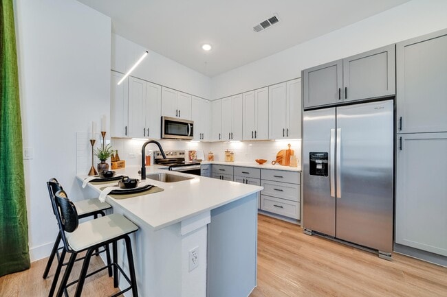 Kitchen with all stainless steel appliances and white cabinets - parcHAUS at Paloma Creek