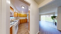 Located in Redmond, WA, this two-story home offers 4 bedrooms and 3 bathrooms spread across two well-proportioned floors. The main level features an open-concept kitchen and living room, where warm honey-toned cabinetry, white appliances, and hardwood-style flooring define the kitchen space. The adjacent living room is bright and airy, with large sliding glass doors framed by vertical blinds that invite generous natural light and views of the surrounding greenery. A tile-surround fireplace serves as a central focal point in the living area, adding warmth and character. The textured ceilings add a classic touch throughout the main floor. Upstairs, the four bedrooms are carpeted for comfort, each featuring mirrored sliding closet doors that enhance the sense of space. The primary bedroom includes convenient access to a hallway with additional storage. The three bathrooms are finished with warm wood-toned vanities, light countertops, and hardwood-style flooring, maintaining a cohesive aesthetic throughout the home. A staircase connects both levels, as visible in the architectural overview. This home combines functional layout with comfortable finishes, making it a well-rounded residence in a desirable Redmond location.