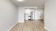 Located at 221 Queen St S in downtown Kitchener, Ontario, this well-appointed one-bedroom unit offers a clean, modern aesthetic throughout its efficiently designed single-floor layout. Light-toned luxury vinyl plank flooring runs seamlessly across all living areas, complementing the crisp white walls and bright flush-mount lighting that give the space a fresh, airy feel.

The open-concept living area provides a generous and flexible space for both relaxing and entertaining. Large windows with warm wood-toned frames invite natural light and offer views of the surrounding neighbourhood, while baseboard heating ensures year-round comfort.

The kitchen is a standout feature, outfitted with full-height white shaker-style cabinetry, marble-look countertops, a decorative tile backsplash, and a complete suite of stainless steel appliances including a refrigerator, stove, and dishwasher — ideal for everyday cooking and meal prep.

The bedroom is a calm, well-proportioned retreat featuring mirrored sliding closet doors that enhance the sense of space and natural light. A private balcony extends the living space outdoors, offering a pleasant spot for fresh air. The unit also includes a bathroom, as visible in the 3D model. Overall, this unit presents a well-maintained, move-in-ready living space in a central Kitchener location.