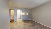 Located at 8711 Cinnamon Creek Dr in San Antonio, TX, this efficiently designed one-bedroom, one-bathroom unit offers a well-planned layout across a single floor. The living room features warm wood-look flooring, neutral gray walls, white baseboards, and a textured ceiling, creating a clean and inviting atmosphere. A ceiling fan provides added comfort and airflow throughout the space. The galley-style kitchen is thoughtfully appointed with white shaker cabinetry, marble-style countertops, stainless steel appliances including a refrigerator, electric range, microwave, and dishwasher, and a single-basin sink. A pass-through window connects the kitchen to the living area, enhancing the open feel. A pantry provides additional storage. The bedroom continues the wood-look flooring and neutral palette, features a ceiling fan, a window with blinds allowing natural light, and access to a dedicated closet. The full bathroom is finished with a white vanity featuring marble-style countertops, white cabinetry, a toilet, and a tub-shower combination with tile surround. Wood-look flooring carries through the bathroom as well, maintaining design consistency throughout the unit.