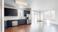 Located at 3108 Brighton Blvd in Denver, Colorado, this single-floor residence offers three bedrooms, two bathrooms, and a well-organized layout designed for comfortable everyday living. The open-concept kitchen and living area serves as the heart of the home, featuring warm hardwood-style flooring, dark cabinetry, granite-look countertops, and a full suite of stainless steel appliances including a refrigerator with ice maker, range, microwave, and dishwasher. Multiple windows flood the combined kitchen and living space with abundant natural light, creating a bright and welcoming atmosphere. A dedicated hallway connects the main living area to the private bedrooms, each finished with plush carpeting and windows that bring in natural light. The primary bedroom offers a comfortable footprint and access to a dedicated closet outfitted with wire shelving for organized storage. Both bathrooms are finished with tile flooring, dark or navy vanity cabinetry, and tub/shower combinations with white tile surrounds. Clean white walls throughout the home contribute to an open, airy feel. The layout is practical and efficient, making thoughtful use of every area within the space.