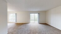Located in Ballwin, MO, this single-floor, three-bedroom, two-bathroom home offers a thoughtfully arranged layout designed for comfortable everyday living. The spacious living room is a standout feature, filled with natural light from large windows and a sliding glass door that opens to a private balcony, making it an inviting space to relax or entertain. Plush carpeting flows throughout the living areas and bedrooms, while wood-style hard flooring runs through the kitchen, hallway, and laundry room. The kitchen is well-appointed with ample cabinetry, generous counter space, a double sink, and includes a full suite of appliances. A dedicated dining area with a chandelier sits adjacent to the kitchen, enhancing the home's functional flow. The primary bedroom is generously sized and features a ceiling fan, large window, and vertical blinds for light control. Additional bedrooms are comfortably proportioned with soft carpeting and ample closet storage — three closets are distributed throughout the home. Both bathrooms are clean and functional, with one featuring a full tub-shower combination with tiled surround. A dedicated laundry room with overhead shelving and washer/dryer hookups adds further convenience to this practical and well-organized home.