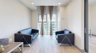 Located on the 15th floor at 256 Lester Street in Waterloo, Ontario, this 2-bedroom, 1-bathroom unit offers a compact yet efficiently designed layout across a single floor. The space includes a kitchen, living room, two bedrooms, a full bathroom, and a hallway.

The kitchen is well-appointed with two-tone cabinetry — white upper cabinets and dark lower cabinets — complemented by granite-look countertops, a marble-style tile backsplash, and a full suite of stainless steel appliances including a refrigerator, stove, and dishwasher. Light wood-style flooring runs throughout, lending warmth and continuity to the space.

The living room is a standout, featuring tall floor-to-ceiling windows dressed with neutral drapes that fill the area with natural light and offer open city views. Two sleek black sofas complete the seating area.

Both bedrooms are bright and functional. The primary bedroom includes a closet and a window with urban views, while the second bedroom features large windows and a dedicated desk area, making it well-suited for study or work.

The bathroom is cleanly finished with grey tile flooring, a shower-tub combination, toilet, and a vanity with under-sink storage. The hallway connects all rooms in a straightforward, practical layout ideal for shared or individual living.