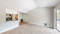 Located in Katy, TX, this single-story, one-bedroom, four-bathroom home offers a well-organized layout across a comfortable footprint. The living room is a standout space, featuring vaulted ceilings that lend an airy, open feel, plush carpeting, and a tile-surround fireplace. Large sliding glass doors lead directly to a private balcony, filling the room with natural light and providing outdoor views. A pass-through opening connects the living area to the kitchen, which is outfitted with white cabinetry, stainless steel appliances including a refrigerator, electric range, and built-in microwave, and wood-look flooring. A dedicated pantry provides additional storage. The adjacent dining room offers a defined space for meals. The bedroom is generously proportioned, featuring soft carpet, a ceiling fan, natural light from a window with blinds, and access to multiple closets. The four bathrooms are clean and functional, each featuring tub-shower combinations and wood-look flooring. Additional conveniences include a dedicated laundry area and ample closet storage throughout. Neutral tones and consistent finishes create a cohesive, move-in-ready ambiance throughout the home.