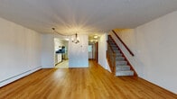 Located at 64 Nutmeg Dr in Meriden, CT, this three-bedroom, three-bathroom home is spread across three floors, offering well-defined living spaces throughout. The entry level includes a garage and utility room, providing practical storage and parking. The main living floor features a bright, open layout with warm hardwood flooring, a chandelier-lit living room, and a staircase with a classic wooden railing and carpeted treads. The kitchen is equipped with white cabinetry, stainless steel appliances including a refrigerator and range, and a window overlooking greenery, allowing natural light to fill the space. A dining nook adjacent to the kitchen adds functional flow to the main level. The upper floor hosts the three bedrooms, each carpeted for comfort and fitted with mirrored sliding closet doors that enhance the sense of space. The generously sized primary bedroom features dual mirrored closets. The three bathrooms include tiled floors, vanities with under-sink storage, and walk-in shower stalls with chrome fixtures. Baseboard heating is present throughout the home, ensuring consistent warmth. Neutral wall tones and wood-trimmed doors and windows give the home a clean, cohesive aesthetic across all levels.