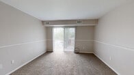Located at 164 Cedar Ridge Dr in Monroeville, PA, this two-bedroom, three-bathroom residence offers a well-organized single-floor layout designed for comfortable everyday living. The living room is a generously sized, carpeted space featuring neutral walls, a ceiling fan, and a sliding glass door that allows natural light to flow in and provides access to the outdoors. A secondary window further brightens the room, creating an open and airy atmosphere. The kitchen is efficiently laid out with white cabinetry, dark countertops, a double stainless steel sink, and a gas range, all set on light tile flooring. The primary bedroom is notably spacious, featuring plush carpet, large windows with blinds, and ample wall space, while the second bedroom offers a similar carpeted, light-filled environment. Three bathrooms serve the residence, each featuring slate-toned tile flooring. The bathrooms include tiled shower-tub combinations, and one features a warm wood-toned vanity with a large mirror and overhead lighting. A hallway connects the rooms efficiently, and a dedicated closet provides additional storage. The overall color palette of warm neutrals throughout creates a cohesive and functional living environment.