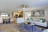 This single-story residence in Newnan, Georgia offers a thoughtfully arranged floor plan that balances comfort and functionality throughout its living spaces. The living room serves as a central gathering area, featuring wood-look flooring, crown molding, a textured ceiling with a ceiling fan, and a glass door that invites natural light and provides outdoor access. The adjacent dining area is defined by warm neutral tones, crown molding, and hardwood-style flooring, creating an inviting setting for meals and entertaining.

The galley-style kitchen is efficiently designed with white cabinetry, granite-look countertops, stainless steel appliances, and wood-look flooring that enhances its clean, contemporary aesthetic. A pass-through connects seamlessly to additional areas of the home.

The bedrooms are carpeted and finished in soft neutral tones, each featuring ceiling fans and windows that allow natural light to filter in. The primary bedroom is notably spacious, offering a walk-in closet and direct bathroom access. Additional bedrooms provide generous space and closet storage.

The bathrooms are well-appointed, featuring white vanities with granite-style countertops, wood-look flooring, and shower-tub combinations, maintaining a cohesive and clean design throughout the home.