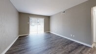 Located at 717 S Great Southwest Pkwy in Grand Prairie, TX, this 2-bedroom, 1-bathroom single-story unit offers a practical and well-appointed layout across a compact, efficiently designed floor plan. Wood-look luxury vinyl plank flooring runs throughout every room, providing a cohesive, low-maintenance foundation that ties the space together. Neutral gray and taupe wall tones complement the flooring and create a clean, modern aesthetic throughout.

The living room receives generous natural light through a large sliding glass door fitted with vertical blinds, brightening the space and offering outdoor access. Adjacent to the living area, the galley-style kitchen features white cabinetry with modern hardware, a single-basin sink, and black appliances, providing functional storage and prep space.

Each bedroom is equipped with a ceiling fan with light kit and windows fitted with horizontal blinds for light control and privacy. The primary bedroom offers a notably spacious footprint, with a closet and direct access to the hallway. The second bedroom mirrors the same clean finishes and ceiling fan setup. A connecting hallway links the bedrooms, bathroom, and main living areas for a logical traffic flow. The full bathroom is accessible from the hallway, serving both bedrooms conveniently. Overall, the unit presents a tidy, move-in-ready interior with consistent finishes throughout.