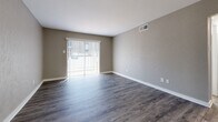 Located at 717 S Great Southwest Pkwy in Grand Prairie, TX, this 2-bedroom, 1-bathroom single-story unit offers a practical and well-appointed layout across a compact, efficiently designed floor plan. Wood-look luxury vinyl plank flooring runs throughout every room, providing a cohesive, low-maintenance foundation that ties the space together. Neutral gray and taupe wall tones complement the flooring and create a clean, modern aesthetic throughout.

The living room receives generous natural light through a large sliding glass door fitted with vertical blinds, brightening the space and offering outdoor access. Adjacent to the living area, the galley-style kitchen features white cabinetry with modern hardware, a single-basin sink, and black appliances, providing functional storage and prep space.

Each bedroom is equipped with a ceiling fan with light kit and windows fitted with horizontal blinds for light control and privacy. The primary bedroom offers a notably spacious footprint, with a closet and direct access to the hallway. The second bedroom mirrors the same clean finishes and ceiling fan setup. A connecting hallway links the bedrooms, bathroom, and main living areas for a logical traffic flow. The full bathroom is accessible from the hallway, serving both bedrooms conveniently. Overall, the unit presents a tidy, move-in-ready interior with consistent finishes throughout.