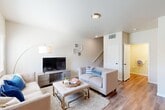 Located at 775 S Belmont St in Delano, CA, this two-story home offers a thoughtfully designed layout spread across two floors. The ground level welcomes you with a bright, open living room featuring warm hardwood-style flooring, neutral walls, and a staircase leading to the upper level. The adjacent combined kitchen and dining area is equipped with stainless steel appliances, including a full-size refrigerator, and offers ample space for everyday dining. A garage with an automatic door opener and tankless water heater adds practical convenience, while a dedicated laundry area rounds out the lower floor. Upstairs, two well-sized bedrooms are finished with plush carpeting and ceiling fans. The spacious primary bedroom receives natural light through a large window with blinds and includes its own closet. Each of the four bathrooms is consistently finished with rich wood-toned cabinetry, granite countertops, and a tub-shower combination, reflecting a cohesive and polished design throughout. With four closets total distributed across the home, storage is plentiful. The clean, neutral palette and modern finishes create a comfortable and functional living environment suitable for a variety of lifestyles.